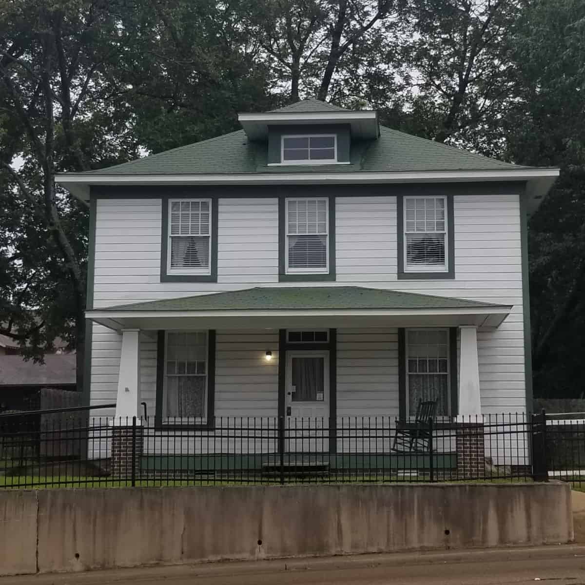 Exterior of two story Clinton Birthplace home with rocking chair on the porch