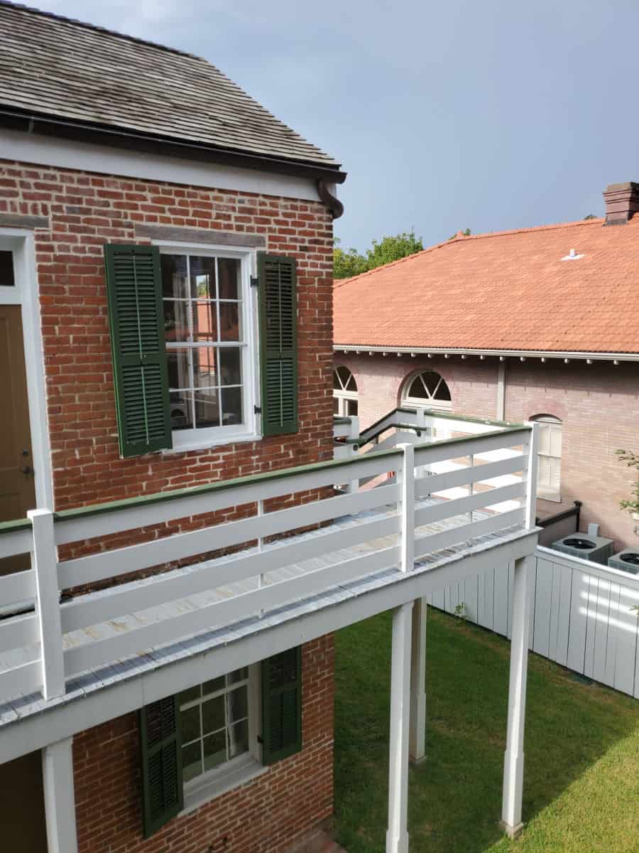 two story brick building with white balcony walkway