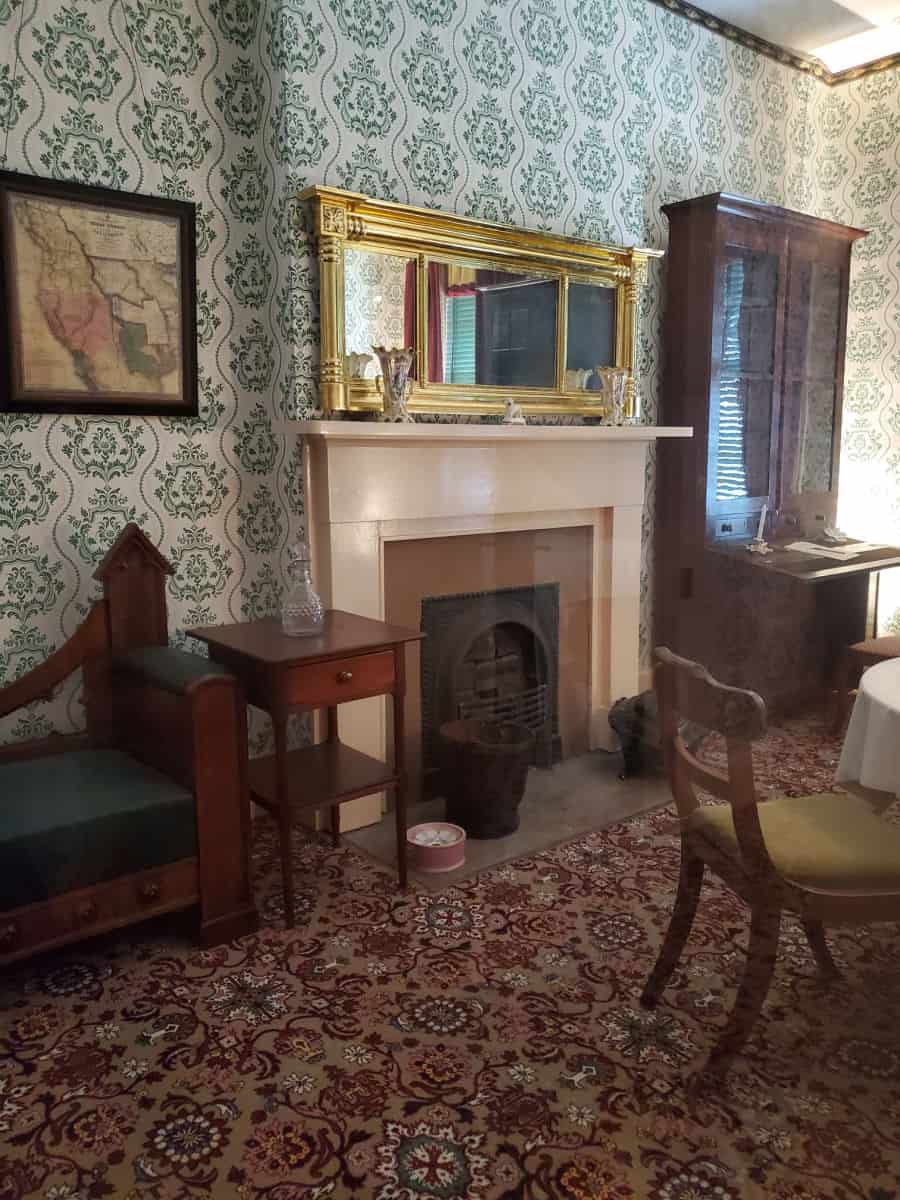 Decorative wallpaper, fireplace, next to a table a chair