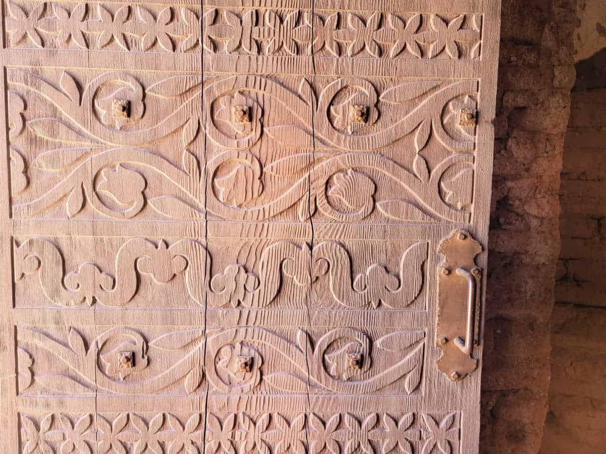 Wood carved door with ornate pattern and handle