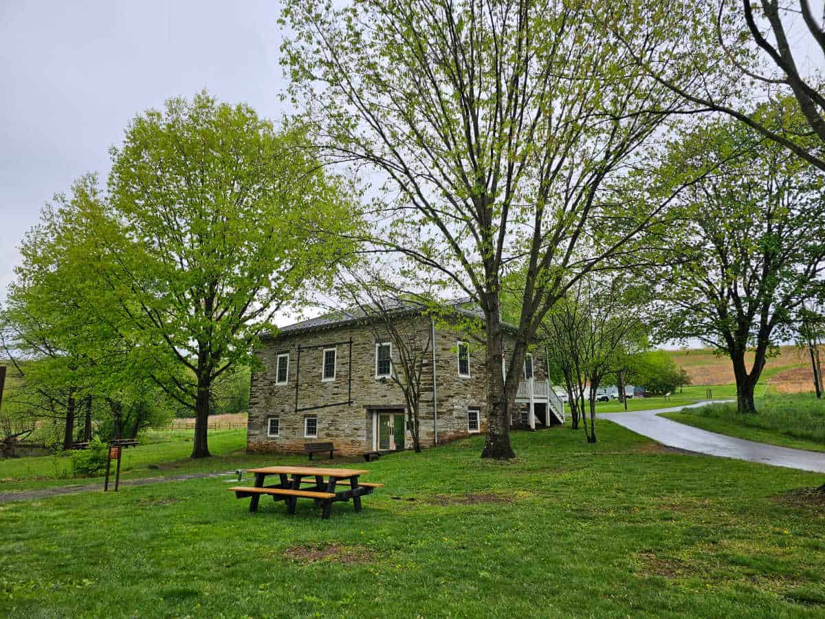 Historic Grambill Mill with picnic table and trees near it. 