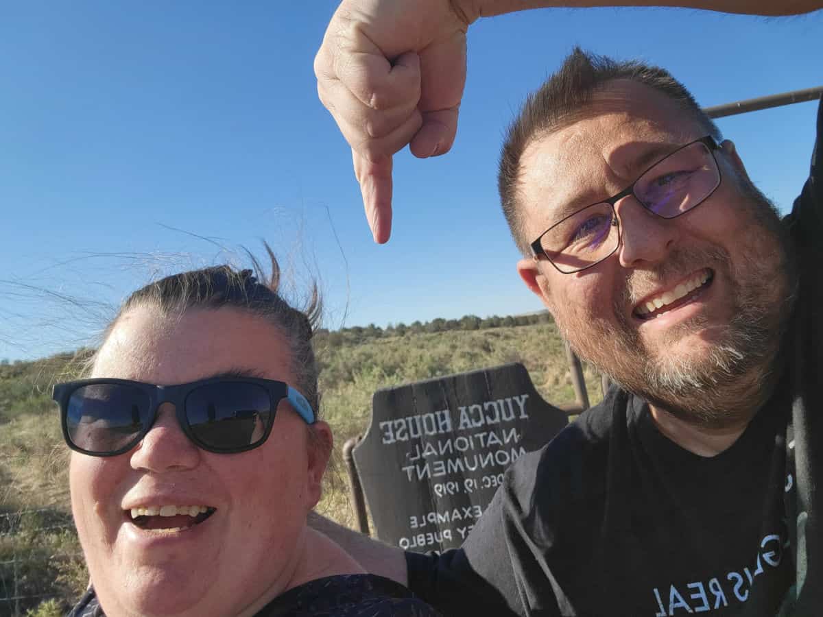 Park Ranger John pointing to the Yucca House National Monument entrance sign