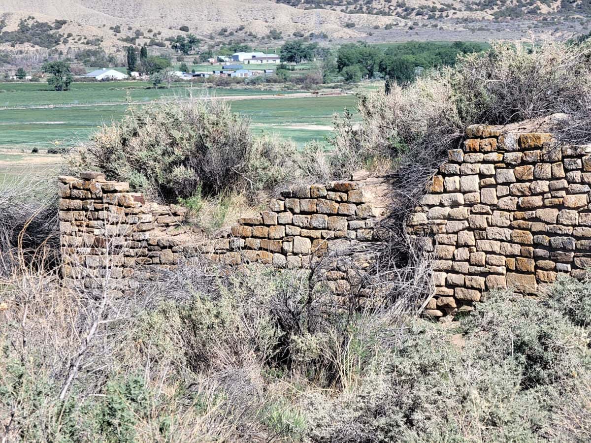 historic stone structure in yucca house nm covered in shrubs