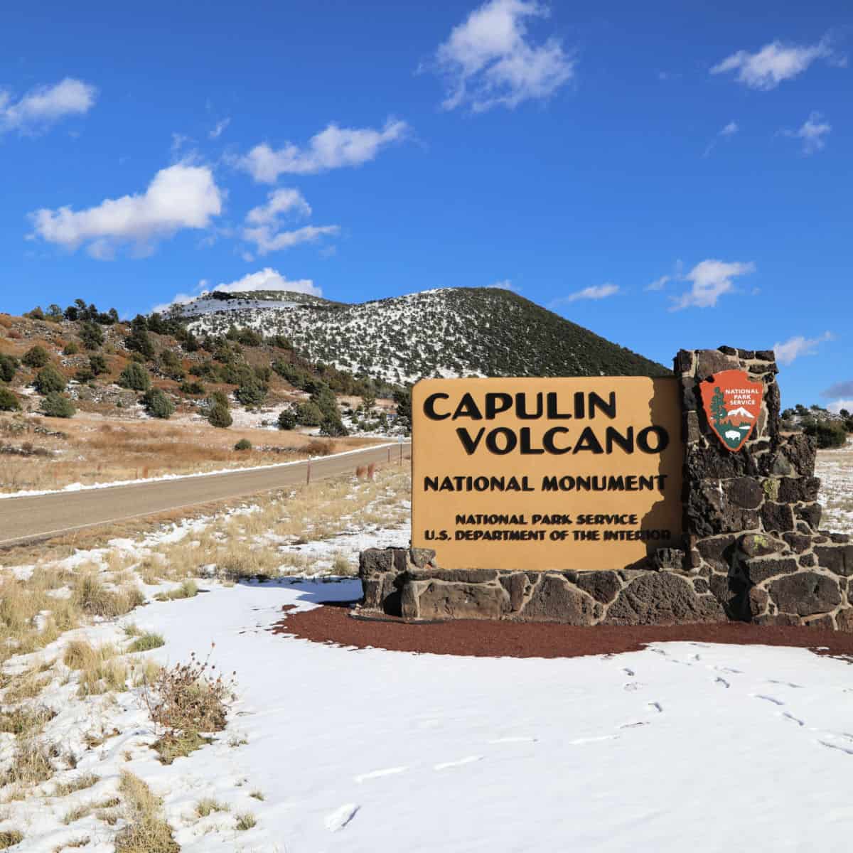Entrance sign with Capulin Volcano in the background at Capulin Volcano National Monument