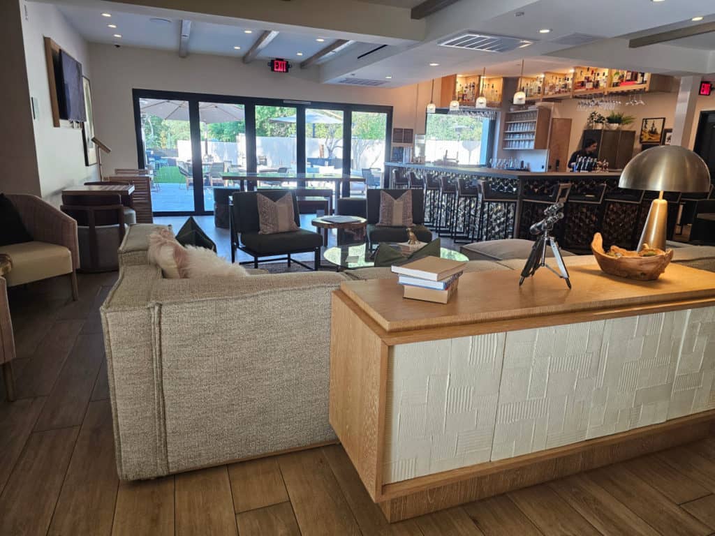 large couch and console table near a bar area with tall chairs