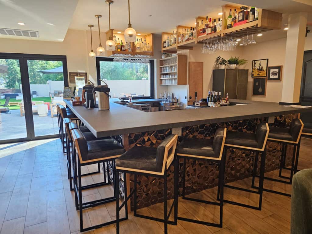 bar with tall chairs, lights, and drinks behind the bar