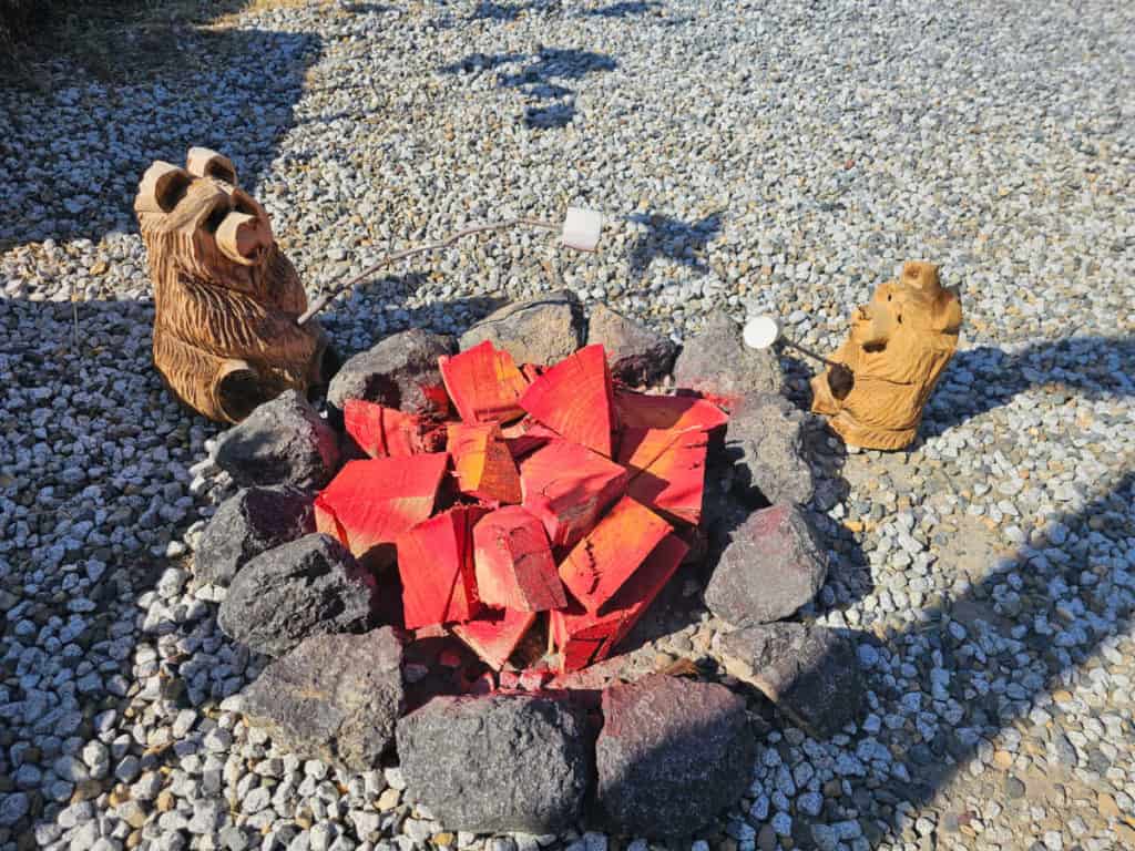 carved bears enjoying smores by a wooden fire