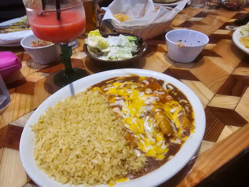 cheese enchilada and strawberry margarita on a table