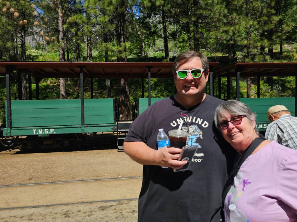 john and his mom in front of green yosemite sugar pine railroad train car