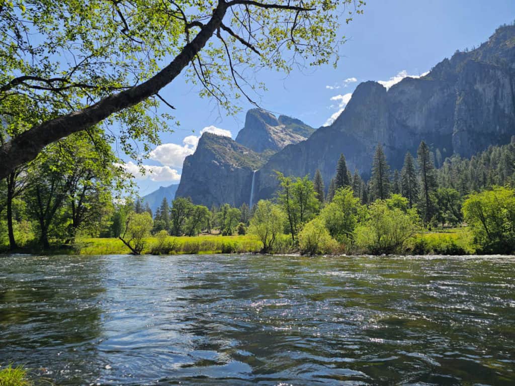bridalveil fall across the merced river with trees and mountains surrounding