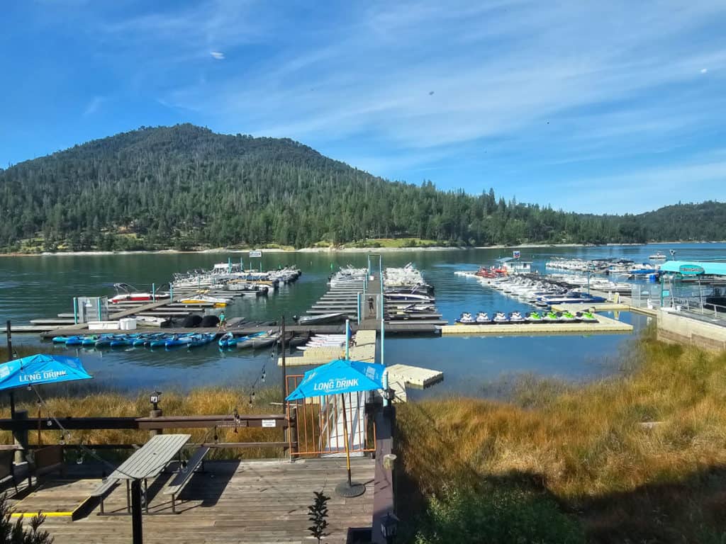 Looking out from Ducey's to Bass Lake on a sunny day with boats at the marina and people on the lake