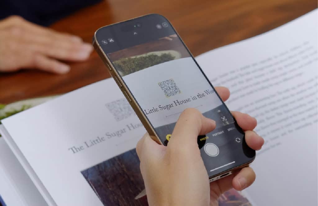 hand holding a phone with a qr code for remento informatio