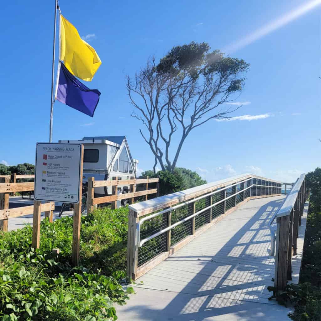 Beach safety flags and boardwalk to the beach from the campground